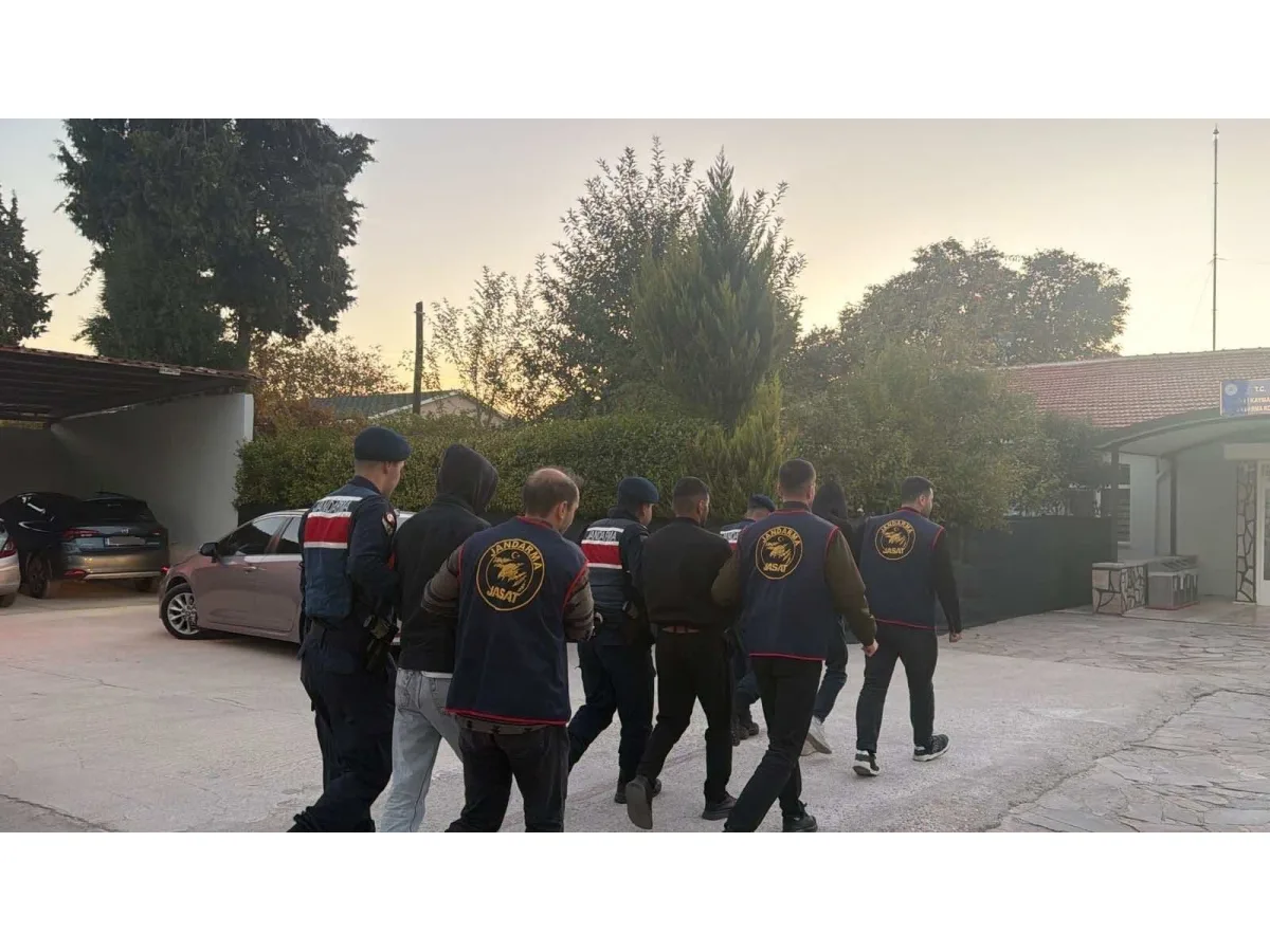Jandarma ekipleri arkası dönük şekilde kişileri götürüyor