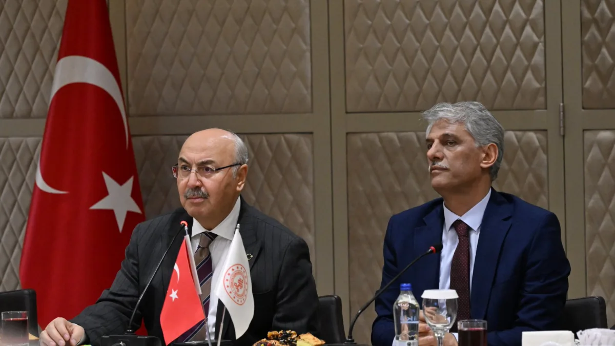 Toplantı masasında oturan iki erkek yetkili