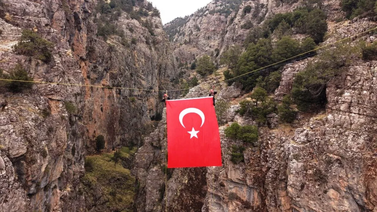 Kayalık kanyonun ortasında dev bir Türk bayrağı asılı duruyor.