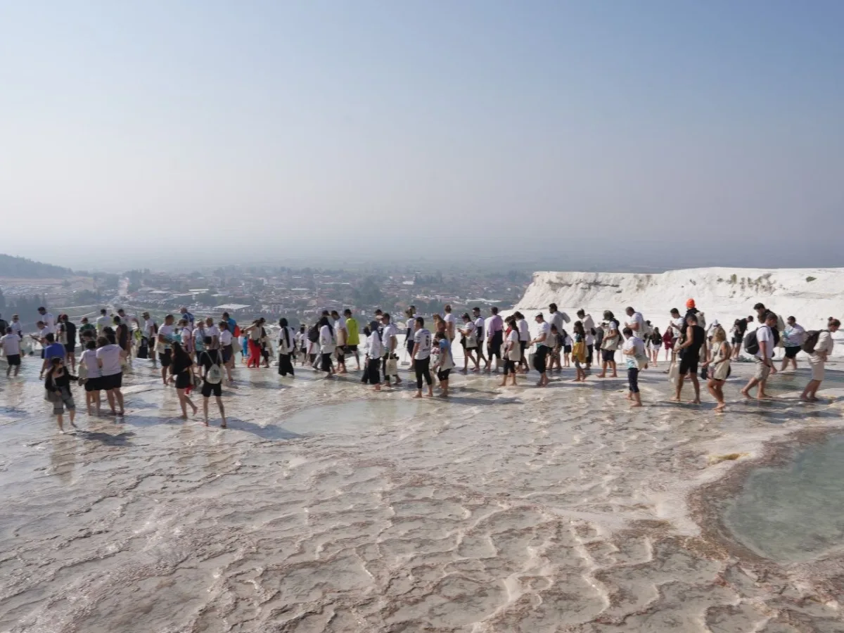 Pamukkale travertenleri üzerinde yürüyen kalabalık bir grup insan